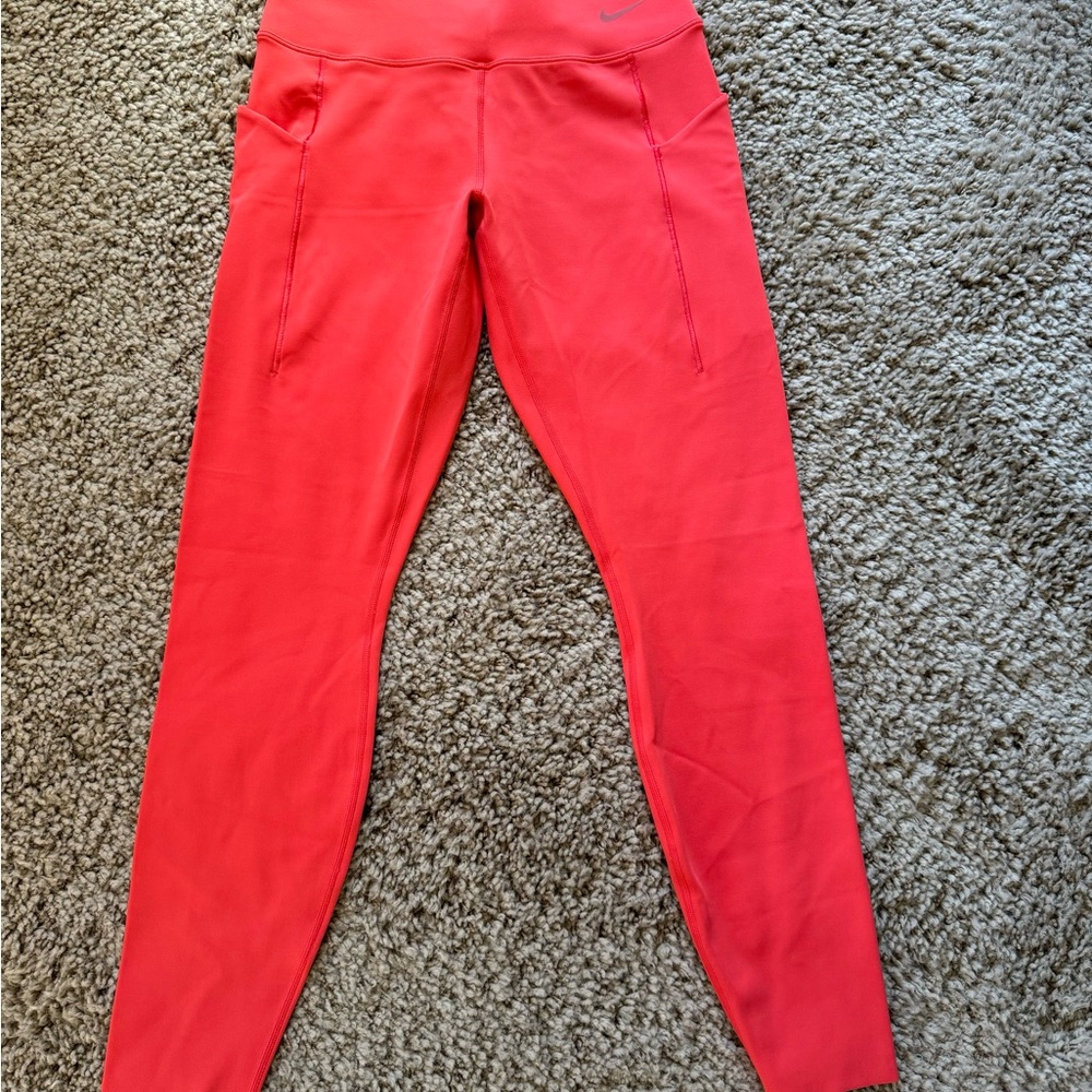 Nike exercise pants in bright orange .